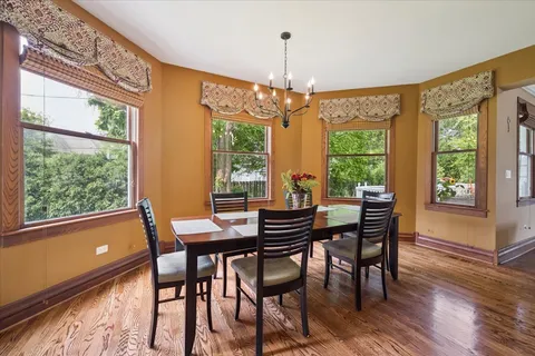 a living room with furniture a chandelier and a dining table