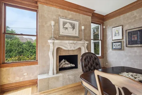 a living room with furniture a fireplace a flat screen tv and a large window