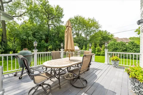 a kitchen with stainless steel appliances granite countertop wooden floors wooden cabinets a sink and a island