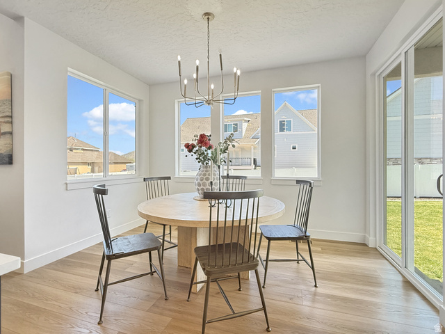 916 Rocky Mountain Way Elk Ridge, UT 84651 - Photo 16 of 54 Dining space featuring suspended lighting, light wood finished floors, and a textured ceiling