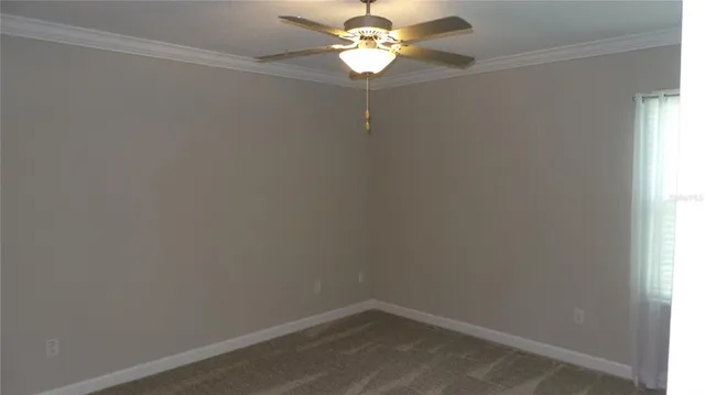 an empty room with a window and a fan