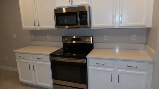 a kitchen with microwave cabinets and stove top oven