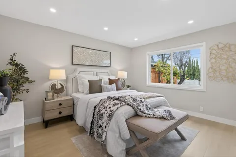 a bedroom with a bed and a painting on the wall