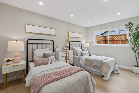 a bedroom with two beds and painting on the wall