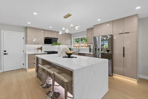 a kitchen with kitchen island a sink stainless steel appliances and refrigerator