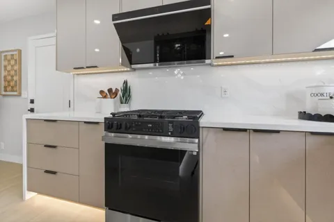 a kitchen with granite countertop white cabinets and black appliances