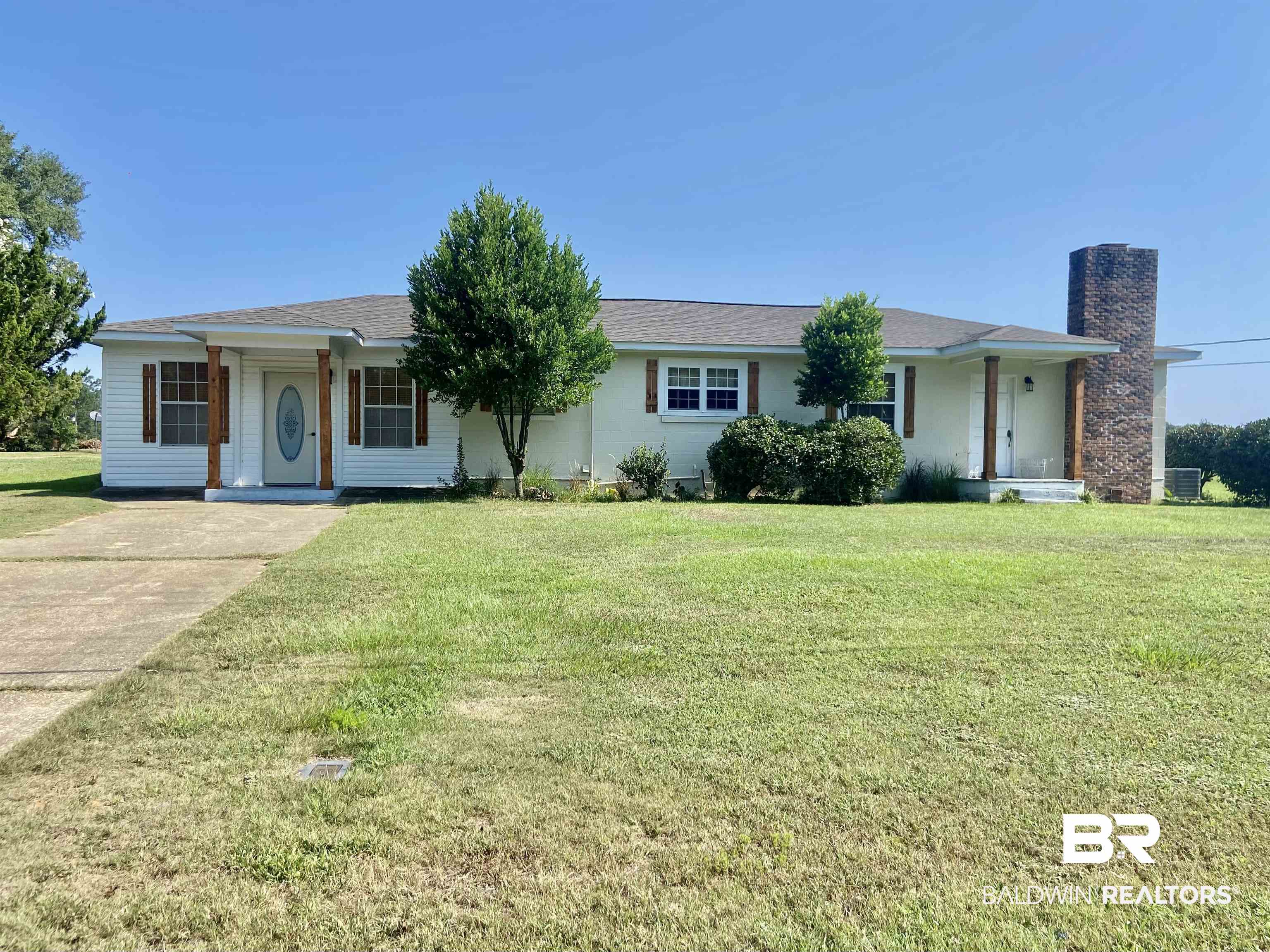 Ranch-style house featuring central AC unit and a front yard