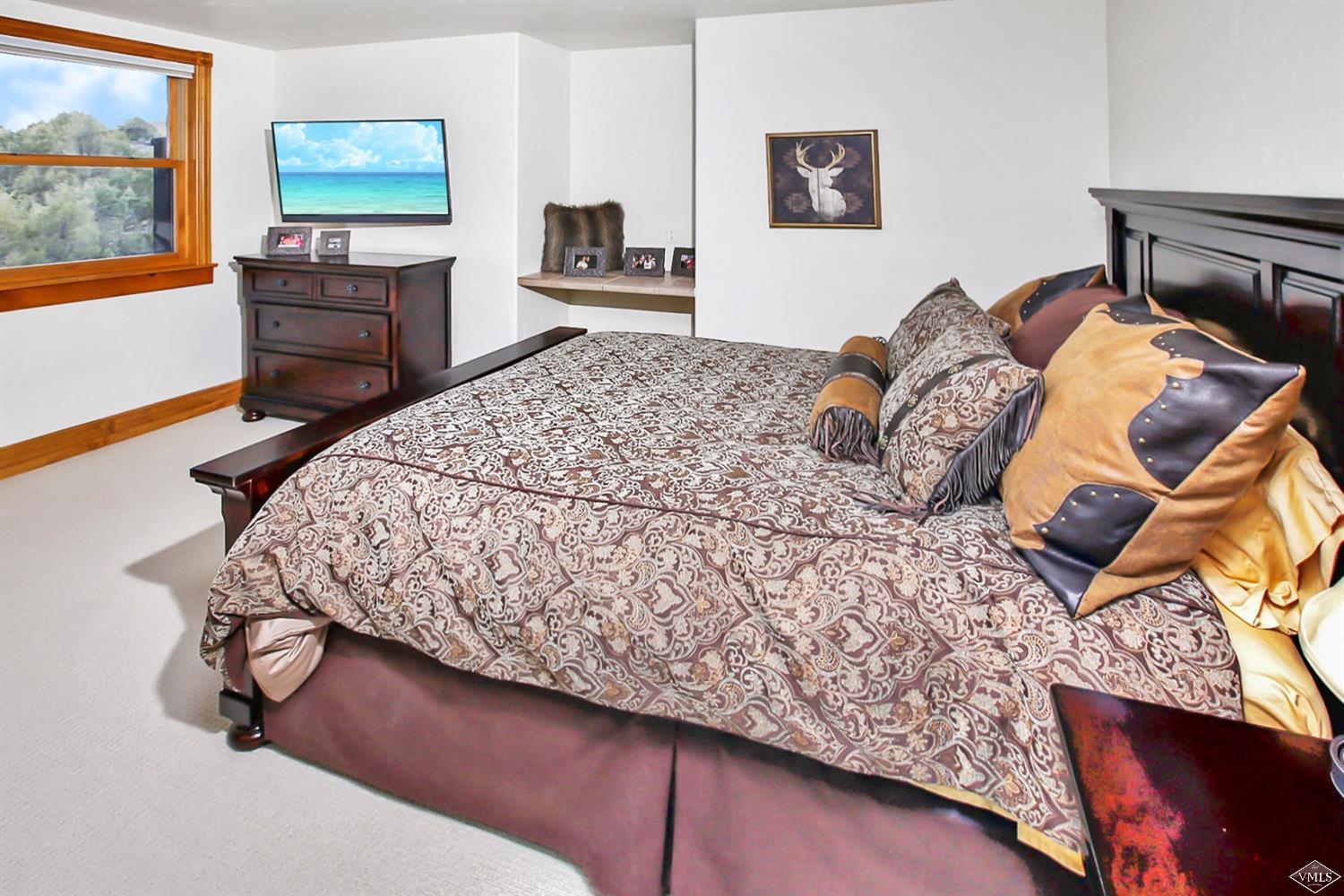 142 Spring Creek Lane Edwards, CO 81632 - Photo 19 of 25 a bedroom with a bed dresser and a flat tv screen