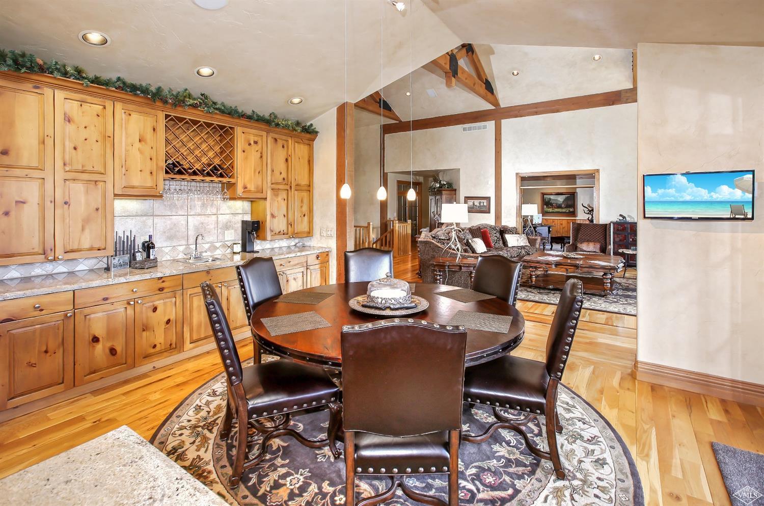 142 Spring Creek Lane Edwards, CO 81632 - Photo 7 of 25 a dining room with furniture a kitchen a chandelier and wooden floor