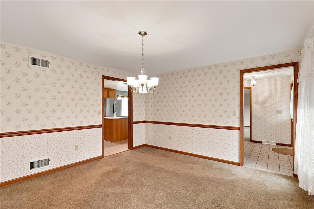 6090 Stone Post Road Bath, PA 18014 - Photo 22 of 57 A well-lit dining area features a classic chandelier and direct kitchen access.