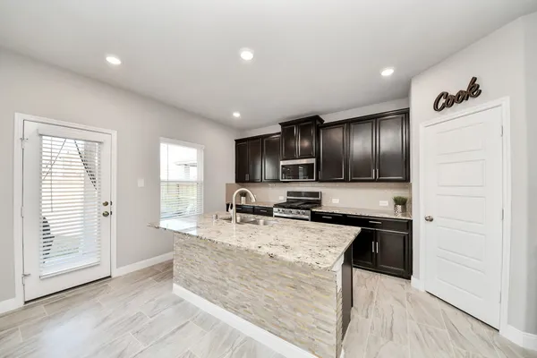 a kitchen with stainless steel appliances granite countertop a sink stove and refrigerator
