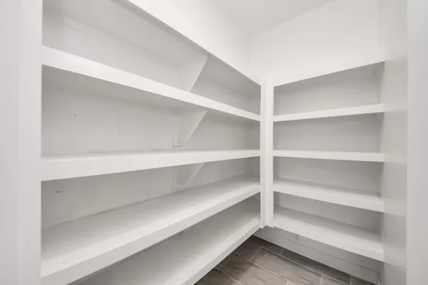 a view of walk in closet with empty racks
