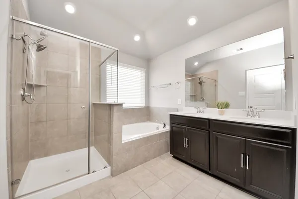 a spacious bathroom with a bathtub shower sink mirror and