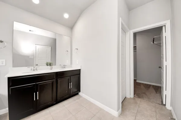 a spacious bathroom with a double vanity sink and mirror
