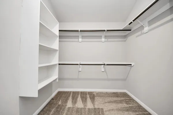 a view of walk in closet with empty racks