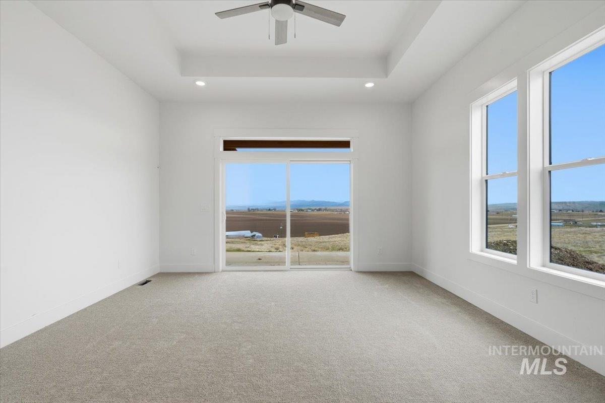 6431 Raptor Ridge Lane Melba, ID 83641 - Photo 26 of 49 Unfurnished bedroom with light colored carpet, connected bathroom, recessed lighting, a ceiling fan, and a raised ceiling