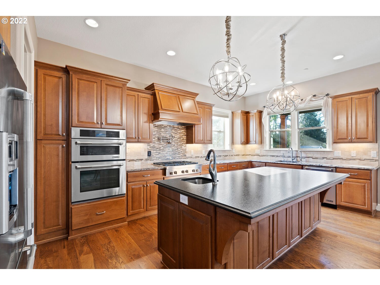 6117 Southwest 67th Place Portland, OR 97223 - Photo 11 of 32 a kitchen with kitchen island granite countertop a stove and a sink