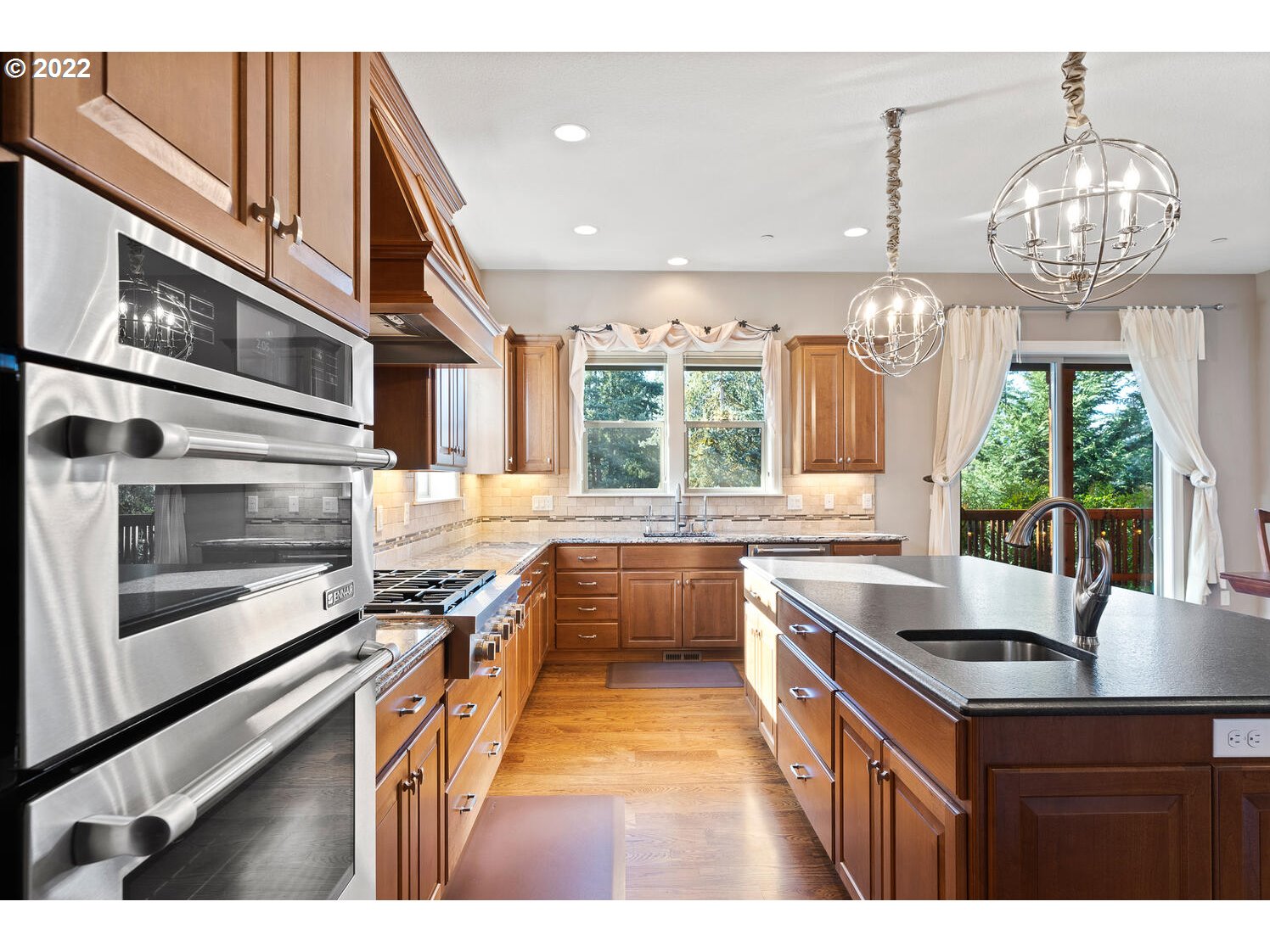 6117 Southwest 67th Place Portland, OR 97223 - Photo 12 of 32 a kitchen with stainless steel appliances granite countertop a sink and stove