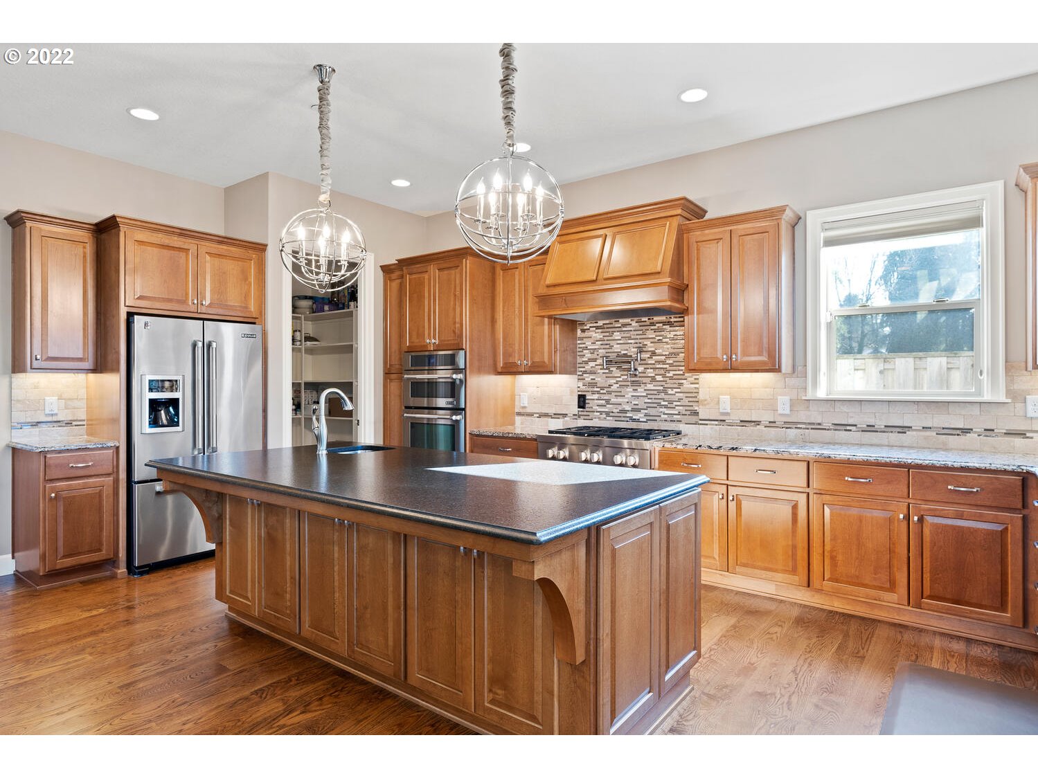 6117 Southwest 67th Place Portland, OR 97223 - Photo 10 of 32 a kitchen with stainless steel appliances granite countertop a sink dishwasher a refrigerator and a wooden cabinets