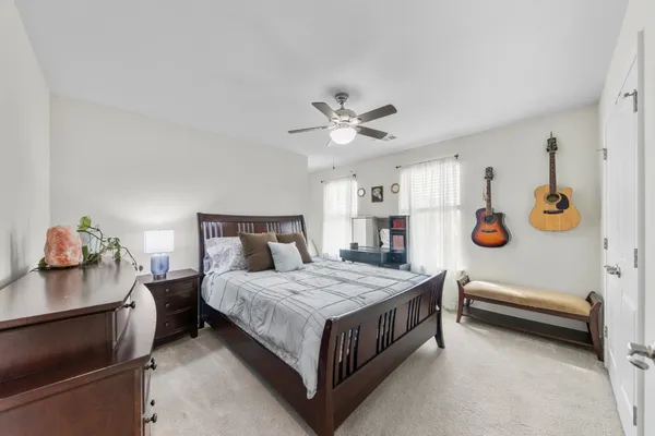 a spacious bedroom with a bed and wooden floor