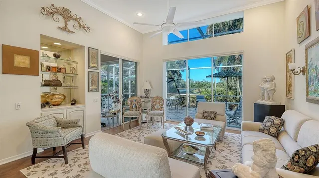 a living room with furniture large window and wooden floor