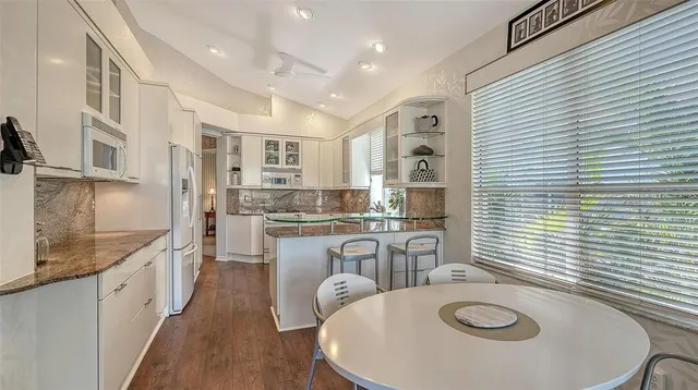 a kitchen with stainless steel appliances granite countertop a refrigerator and a stove top oven