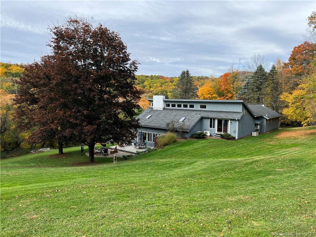a view of a house with a big yard and large trees