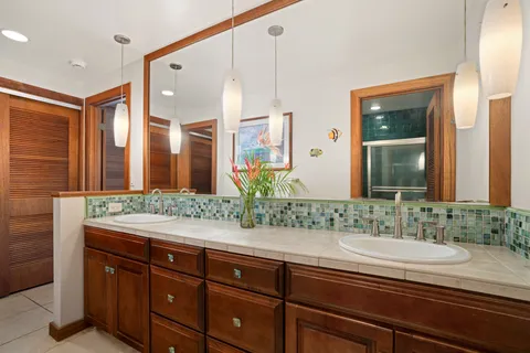 a bathroom with a granite countertop sink and a mirror
