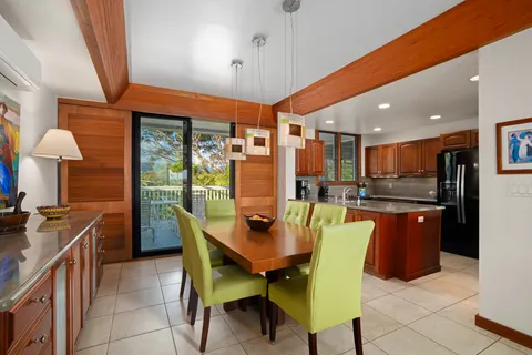 a dining room with a table chairs and a kitchen view