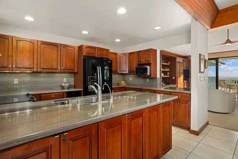 a kitchen with stainless steel appliances granite countertop a sink a stove and a refrigerator