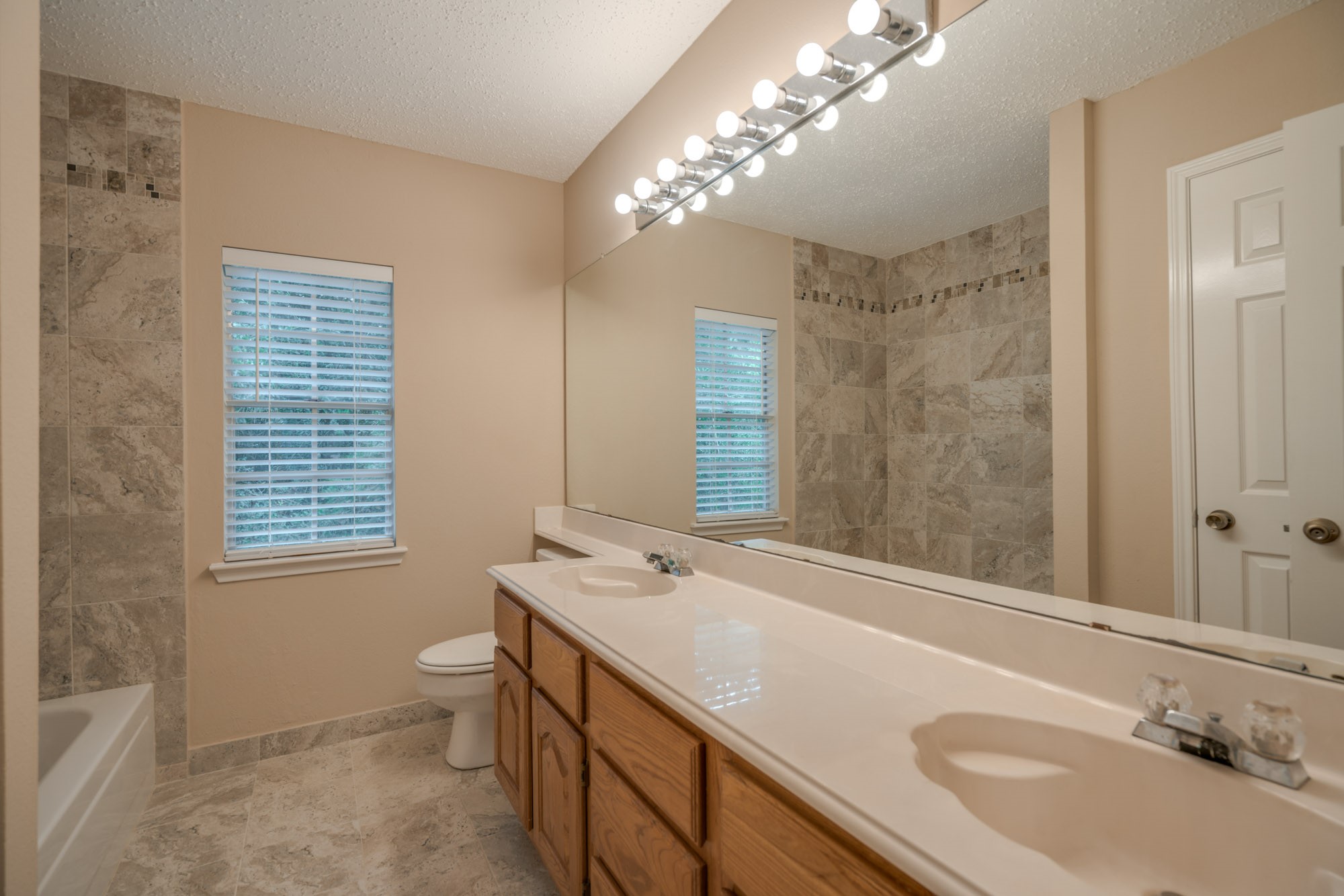 11 Robin Run Drive Spring, TX 77381 - Photo 18 of 25 a bathroom with a sink a large mirror and a bathtub