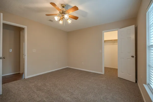 a view of an empty room with a chandelier fan