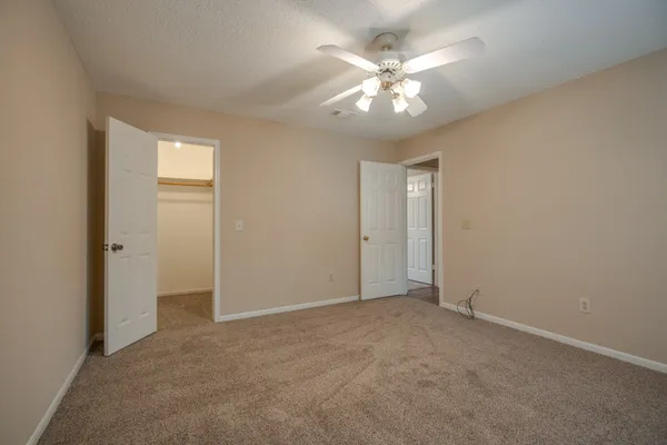 an empty room with a window and a ceiling fan