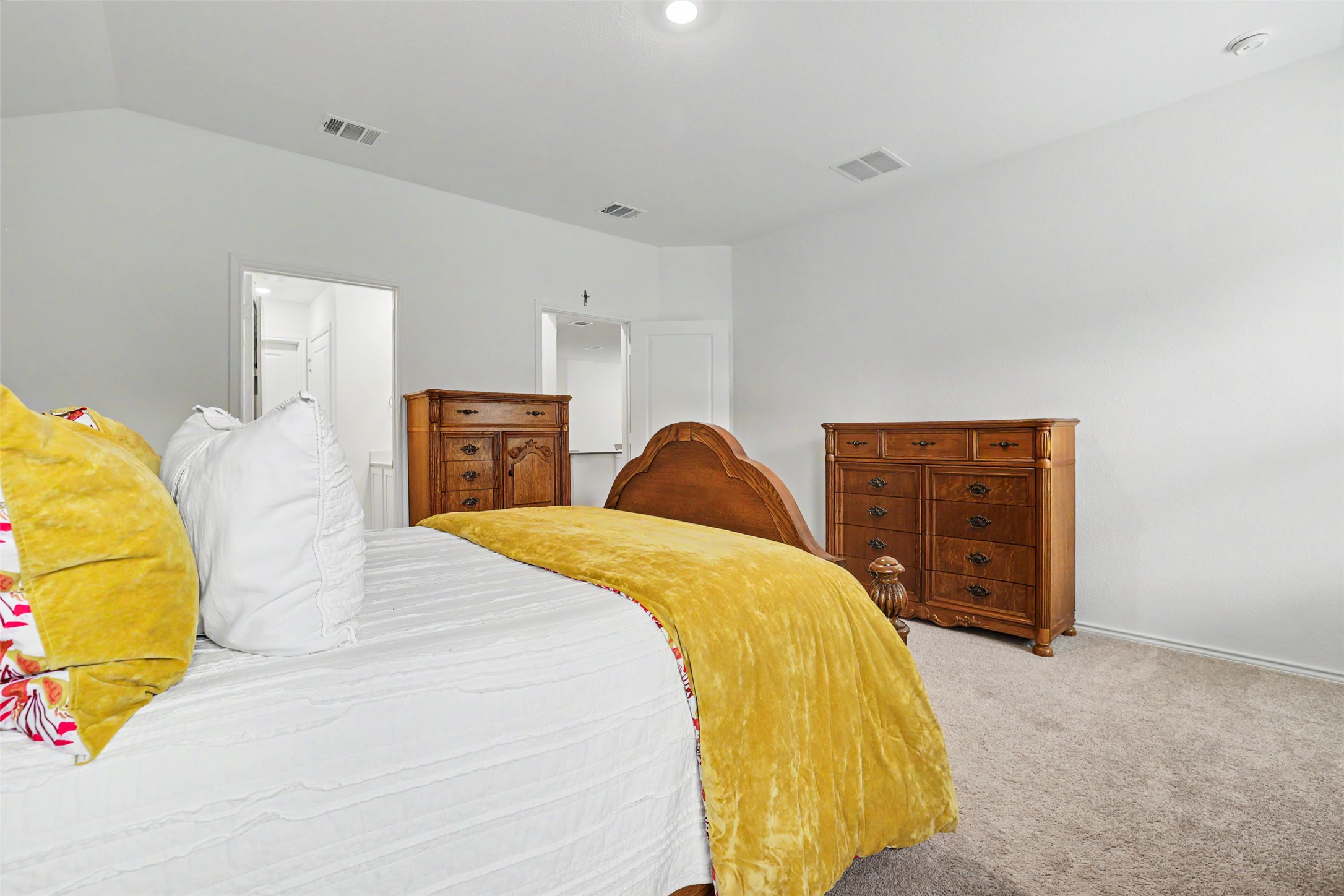 2333 Four Waters Loop Georgetown, TX 78628 - Photo 19 of 35 Spacious bedroom featuring light neutral wall paint, carpet flooring, a vaulted ceiling with recessed lighting, and a doorway leading to another room