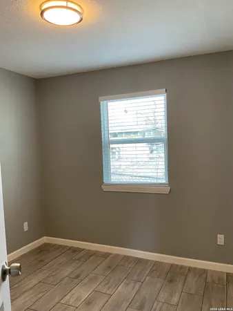 a view of a room with wooden floor and cabinet