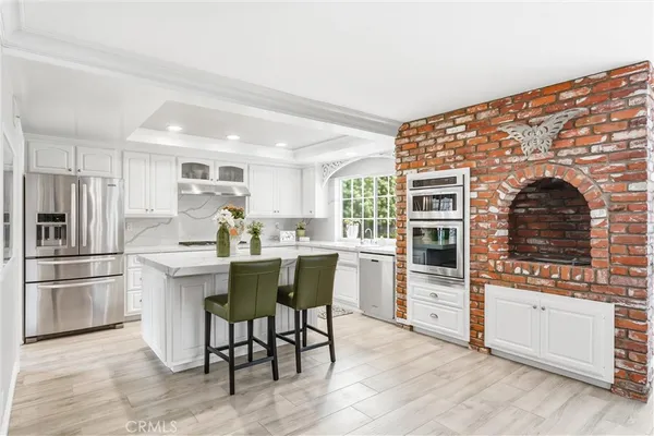 a kitchen with a stove a refrigerator and white cabinets