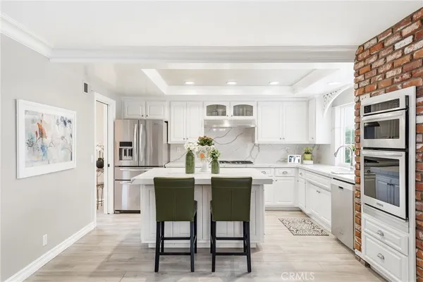 a kitchen with white cabinets and stainless steel appliances