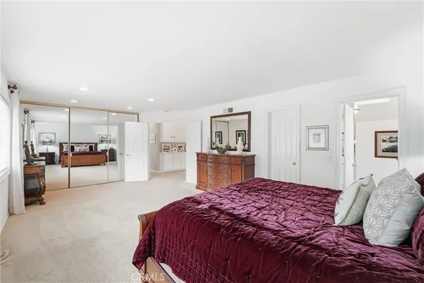 a spacious bedroom with a bed a table and chairs