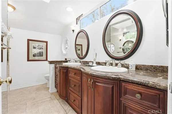 a bathroom with a granite countertop double vanity and a mirror