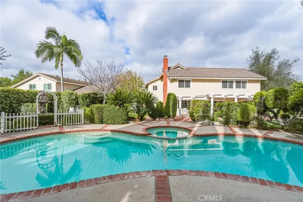 a view of a house with a yard and table and chairs under an umbrella