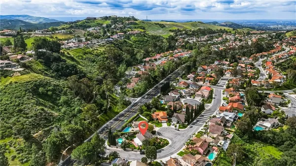 an aerial view of residential houses with outdoor space and trees