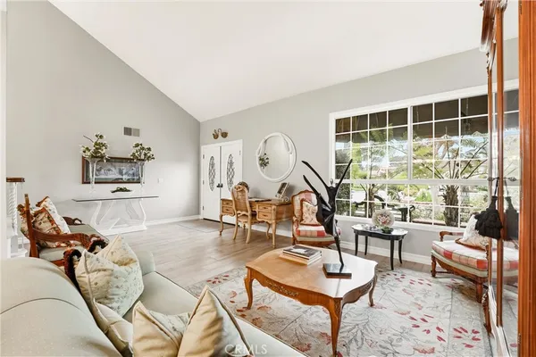 a living room with furniture a rug and a floor to ceiling window