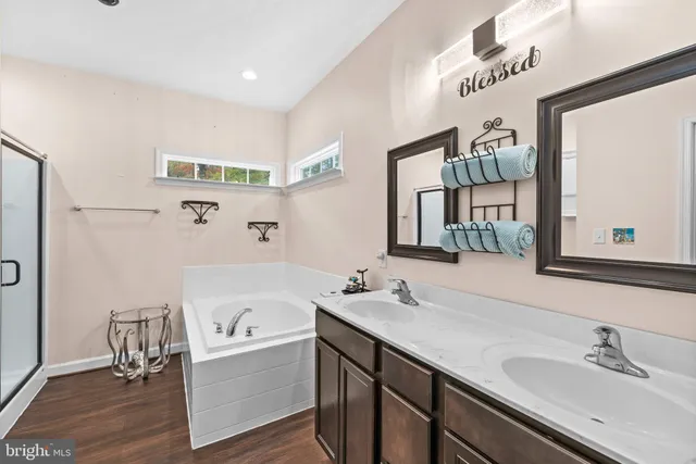 a bathroom with a tub sink and mirror