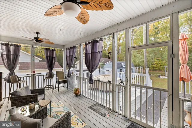 a view of a livingroom with furniture wooden floor fan and a floor to ceiling window