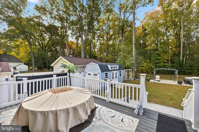 a view of a wooden chairs and fire pit in the backyard