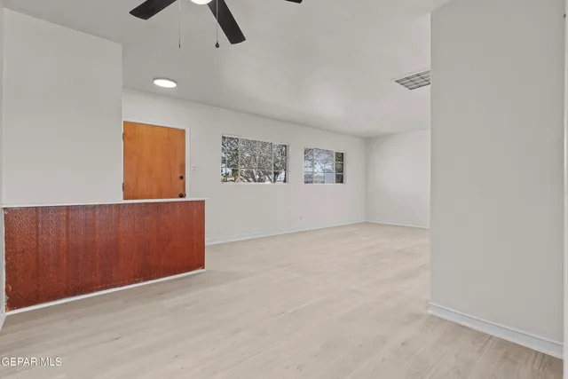 an empty room with windows and cabinet