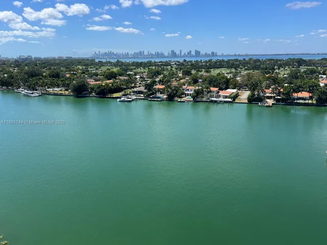 an aerial view of a houses with a yard and lake view