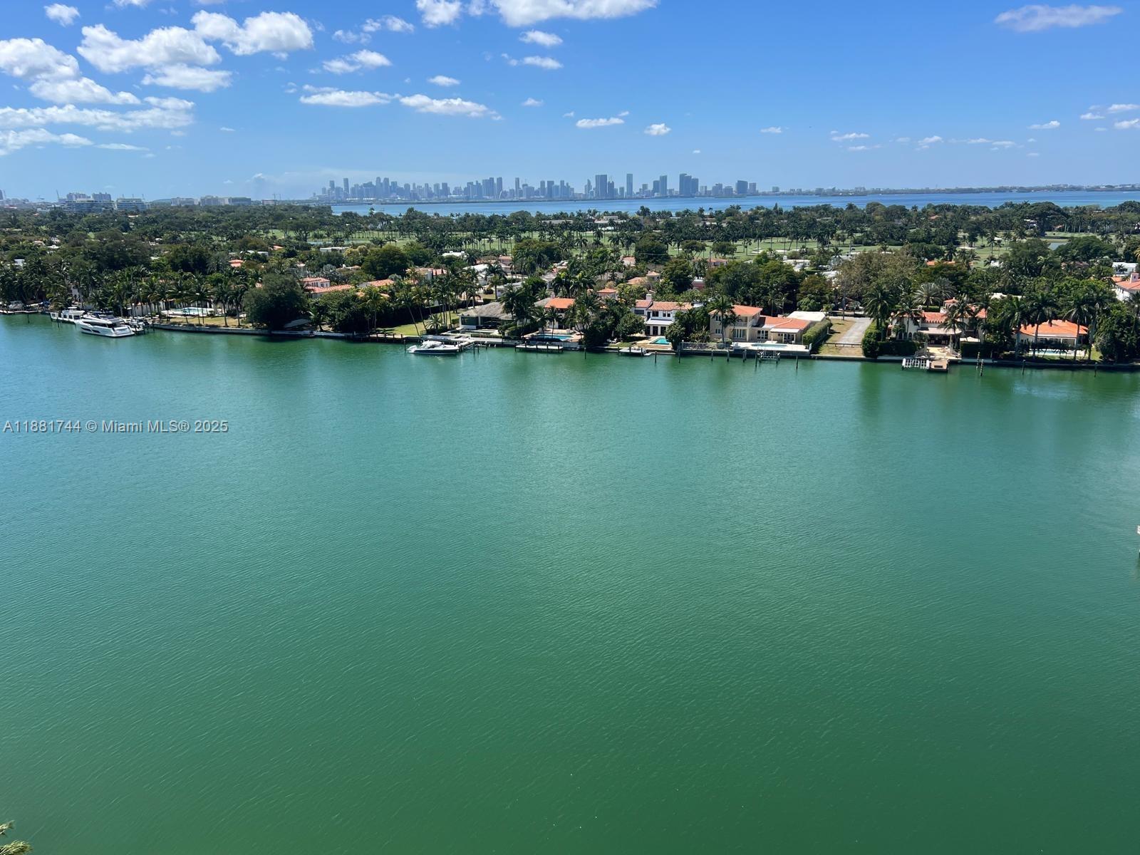 an aerial view of a houses with a yard and lake view
