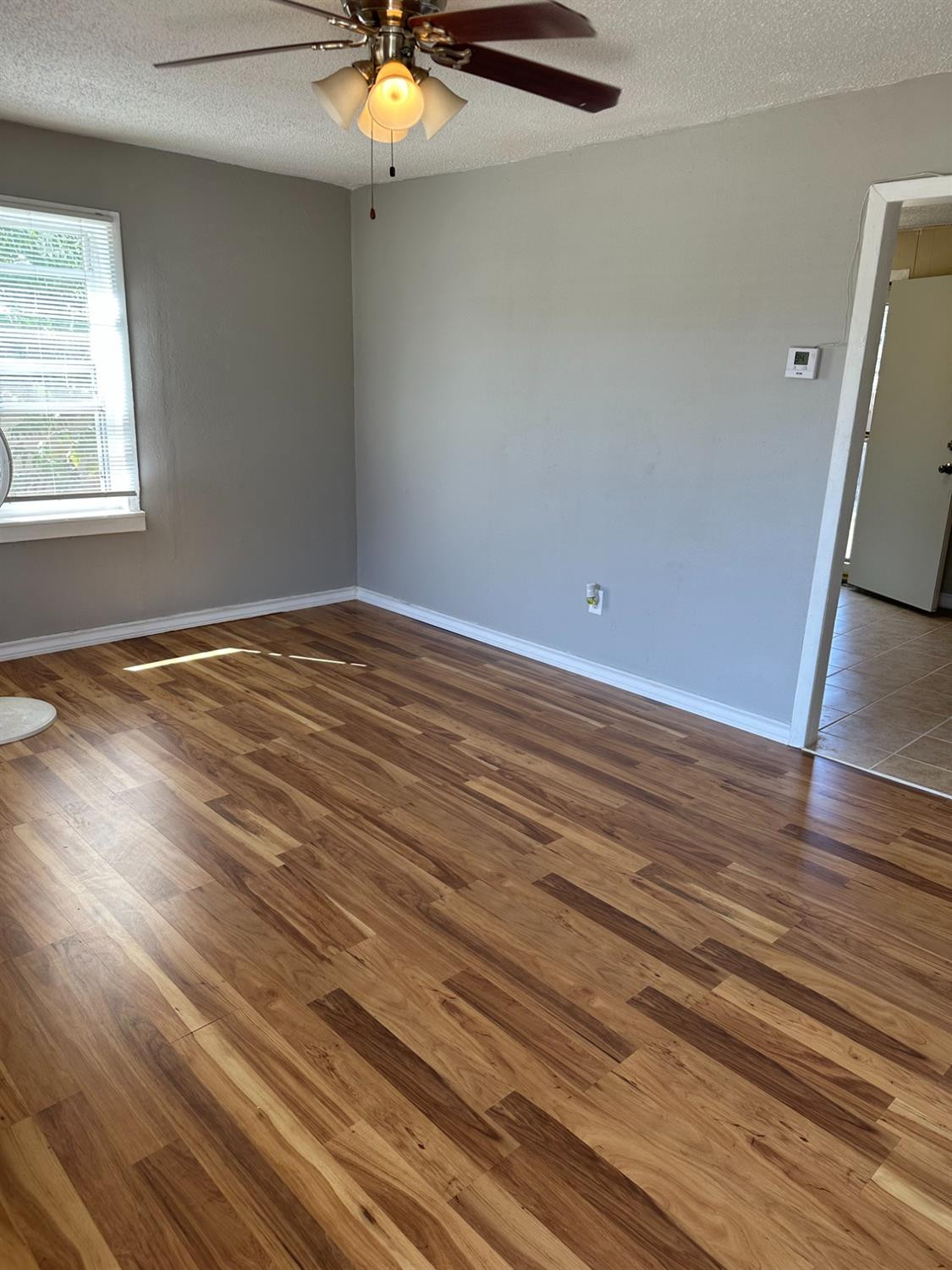 1110 46th Street Lubbock, TX 79412 - Photo 2 of 12 an empty room with wooden floor fan and windows