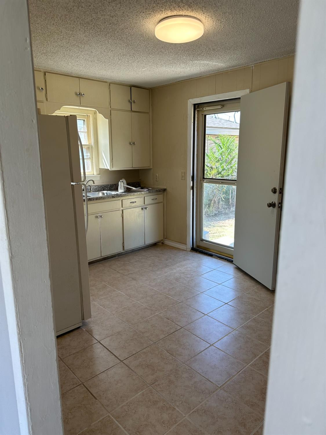 1110 46th Street Lubbock, TX 79412 - Photo 4 of 12 a kitchen with refrigerator and window